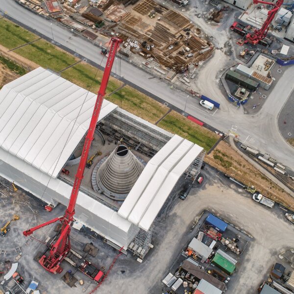 Geöffnetes Layher Kederdach (Wetterschutzdach) zur Kranbeschickung – Witterungsunabhängiges Bauen mit flexibler Baustellenlogistik von Otto Wolf