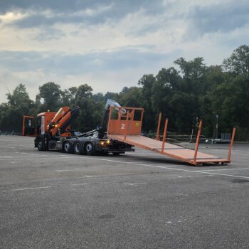 Mercedes-Benz Abrollkipper von Otto Wolf beim Absetzen einer 7m Pritsche – Logistik-Service für Gerüstbau, Zimmerei und mehr