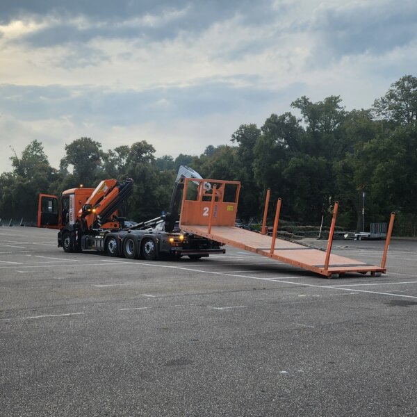 Mercedes-Benz Abrollkipper von Otto Wolf beim Absetzen einer 7m Pritsche – Logistik-Service für Gerüstbau, Zimmerei und mehr