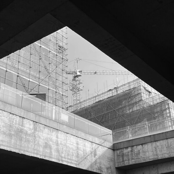 Schwarz-weiß Hintergrundbild eines eingerüsteten Gebäudes für den Header der 'Über uns' Seite von Otto Wolf Gerüstbau – Symbol für Tradition und Beständigkeit