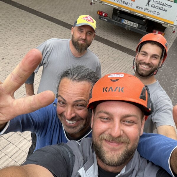 Lachendes Gerüstbau-Team von Otto Wolf – Selfie auf der Baustelle als Zeichen für Motivation und gutes Betriebsklima